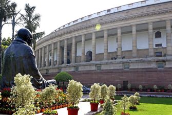 The statue of Mahatma Gandhi amid blooming flowers in the parliament premises